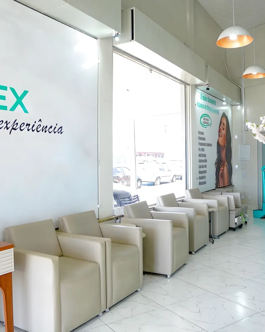 Poltronas junto à vitrine com a lista de serviços e luz natural